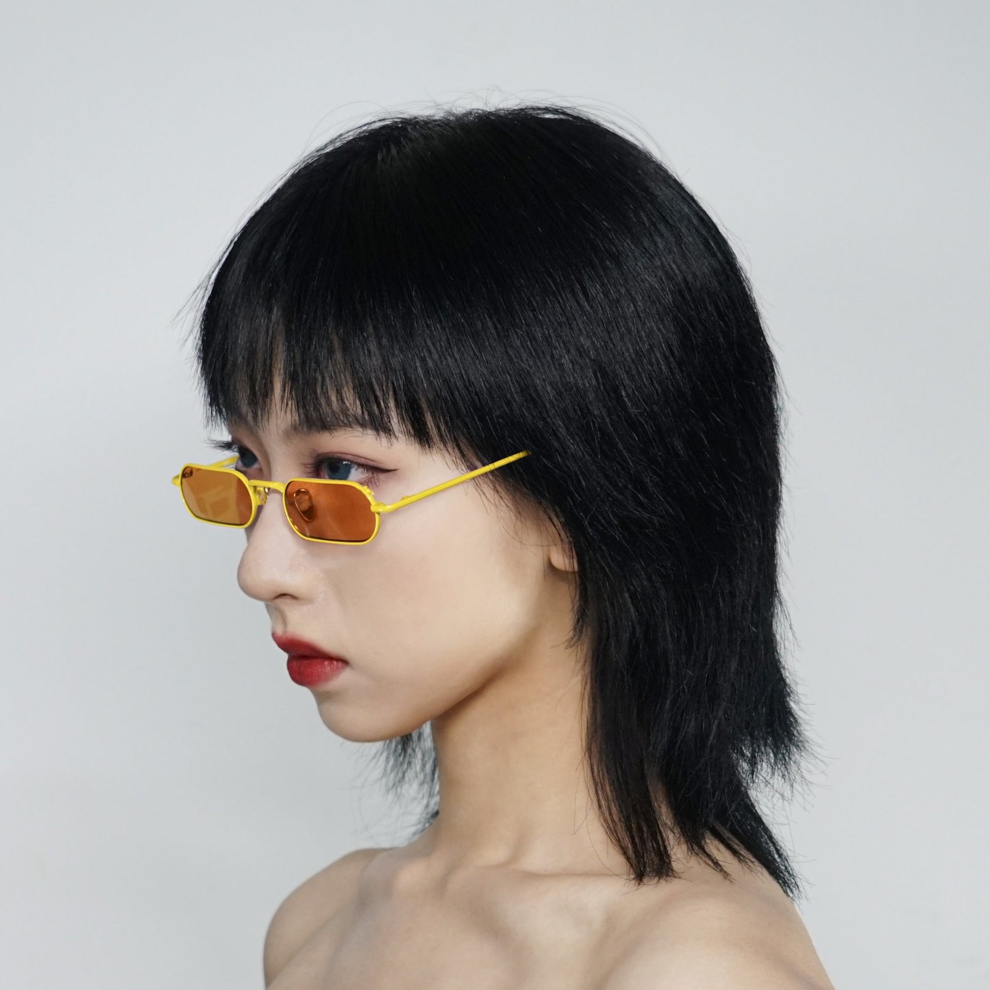 stadium shaped sunglasses with dark yellow lens and yellow stainless steel frame on model 45 angled