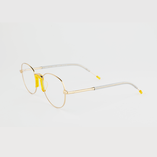 gold colour titanium round optical frame with yellow acetate nose pads and temple tips 45 angled