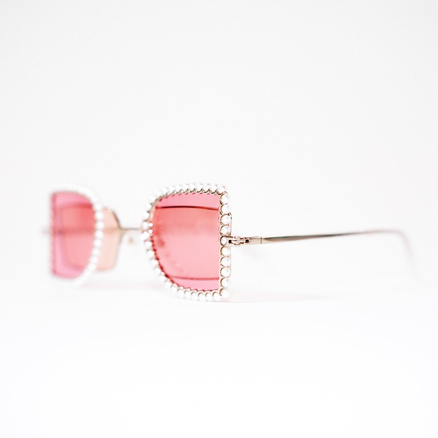 sunglasses with pearl rimmed pink windows closed and pink polaroid lens 45 angled 1