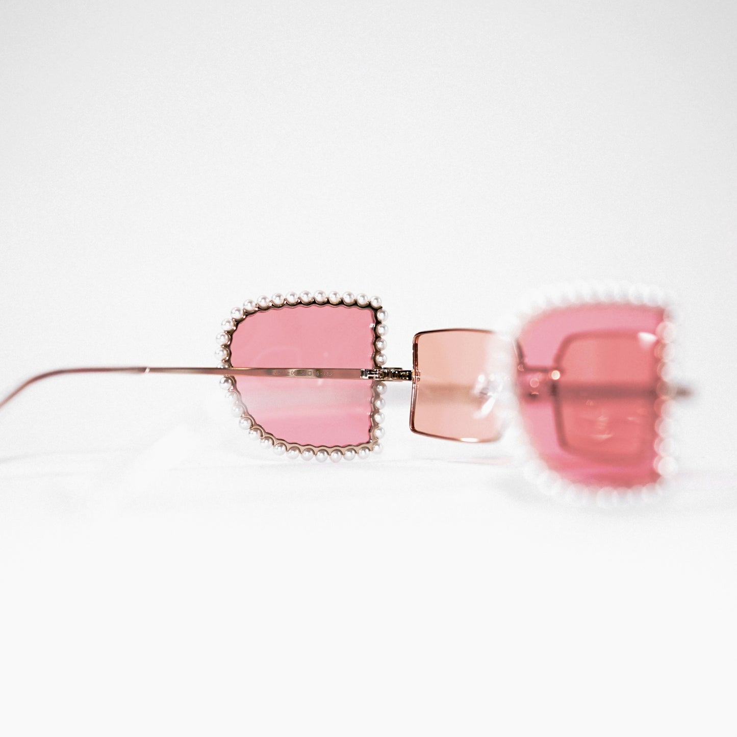 sunglasses with pearl rimmed pink windows opened and pink polaroid lens 45 angled