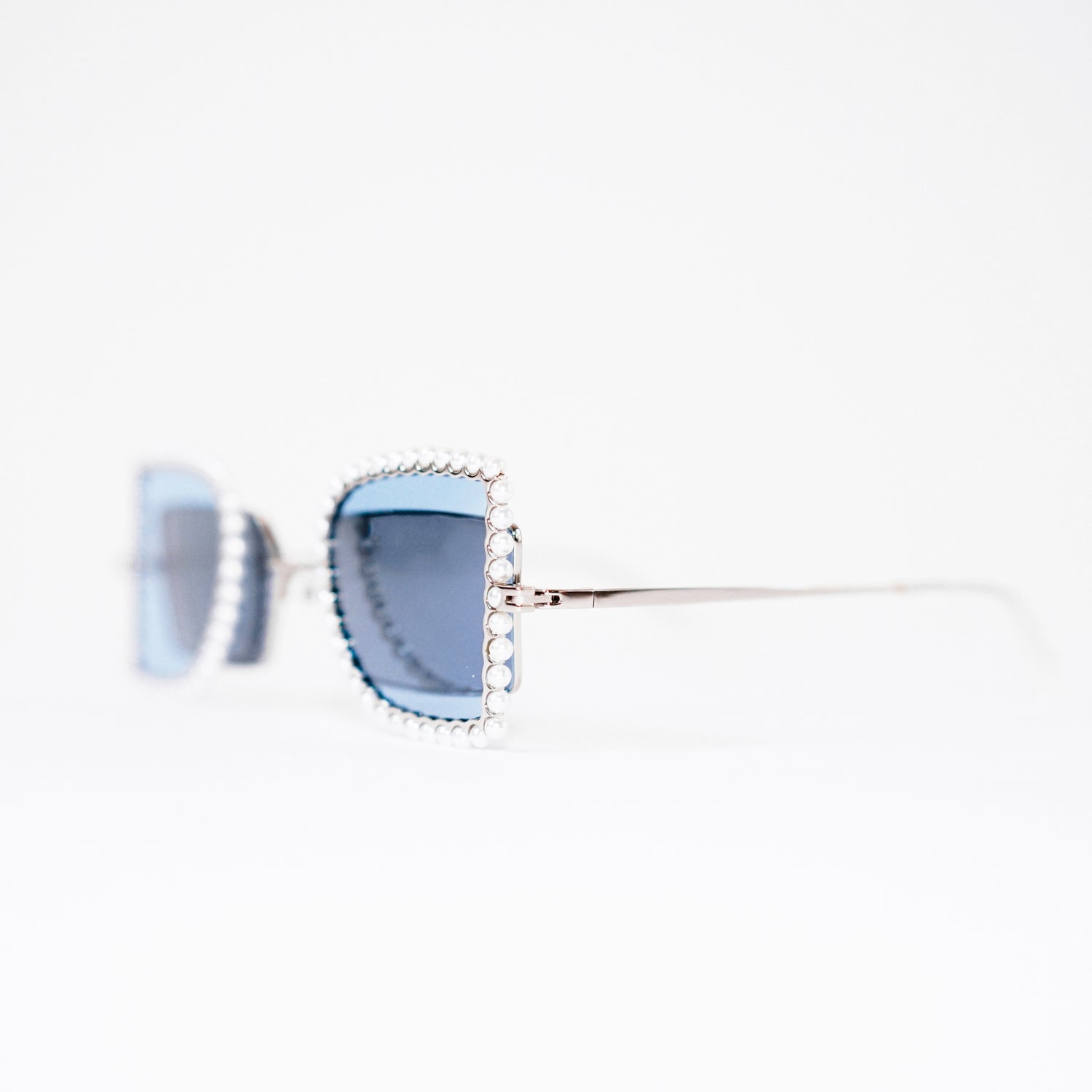 sunglasses with pearl rimmed window closed and blue polaroid lens 45 angled