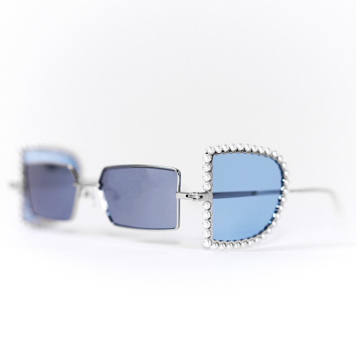 sunglasses with pearl rimmed window opened and blue polaroid lens 45 angled