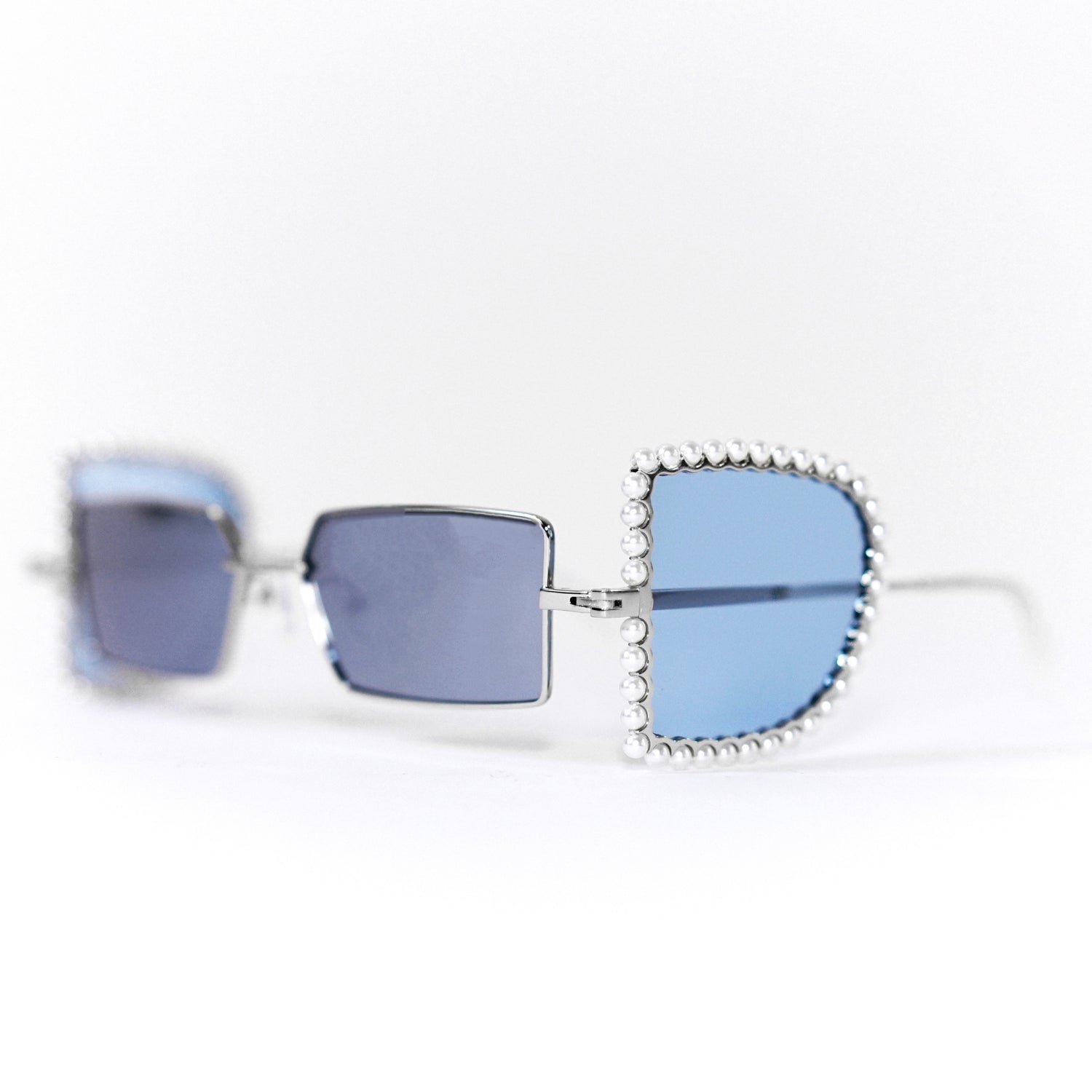 sunglasses with pearl rimmed window opened and blue polaroid lens 45 angled