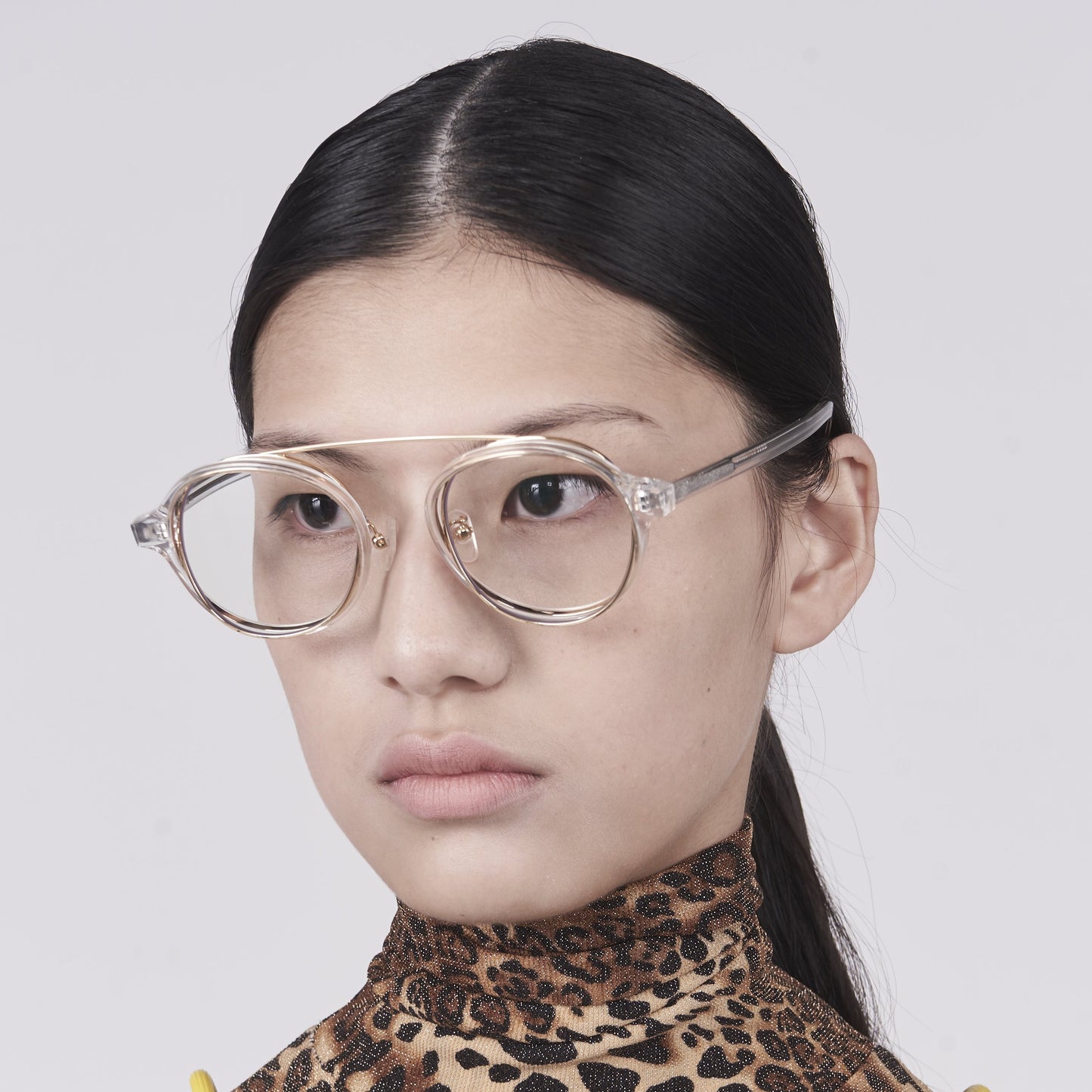 clear acetate round frames with crossed gold rims and clear nylon lens on model 45 angled